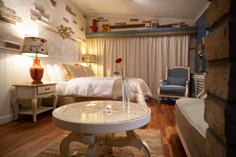 Arnulf Øverland Suite side view, bed and lounge armchair hotel room