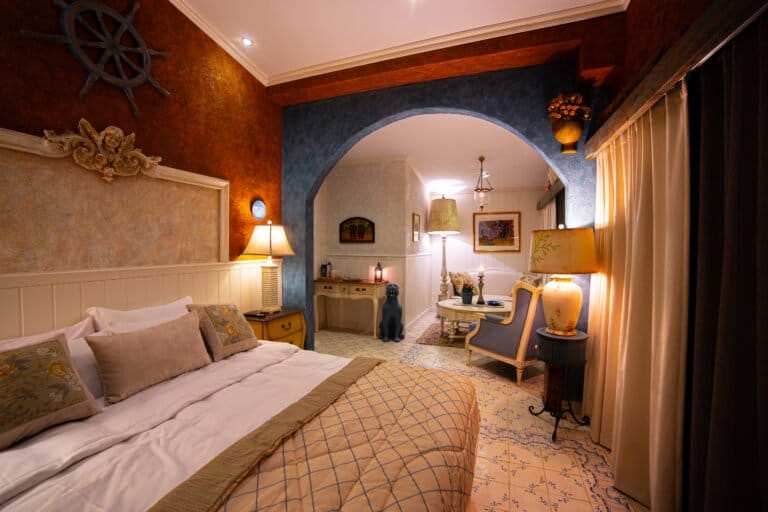 Thor Heyerdahl Suite bed and deep blue arch in a hotel room